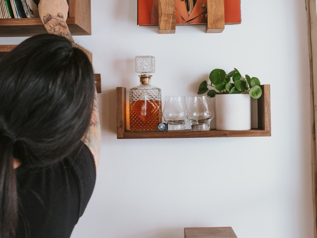 A floating shelf in a U shape underneath a wall-mounted record shelf