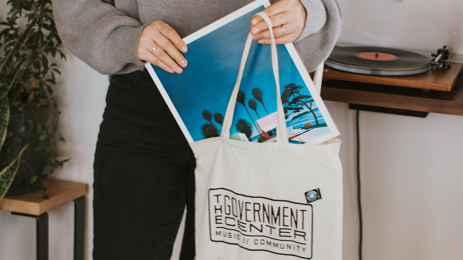 A woman pulling records out of a Government Center Record Store record bag from a Curated Bag of Records from Deep Cut